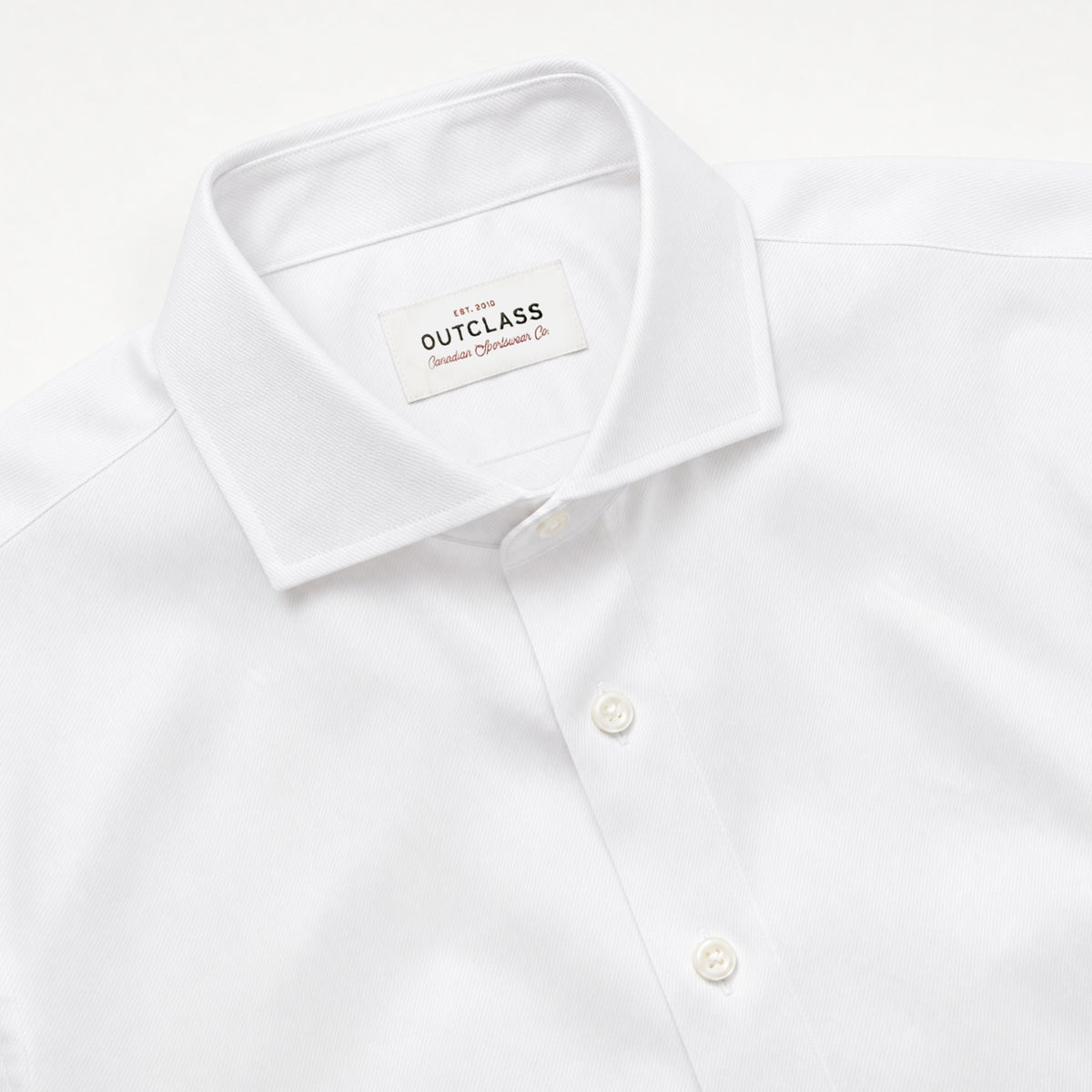 White dress shirt collar with spread neckline, button placket, and brand tag