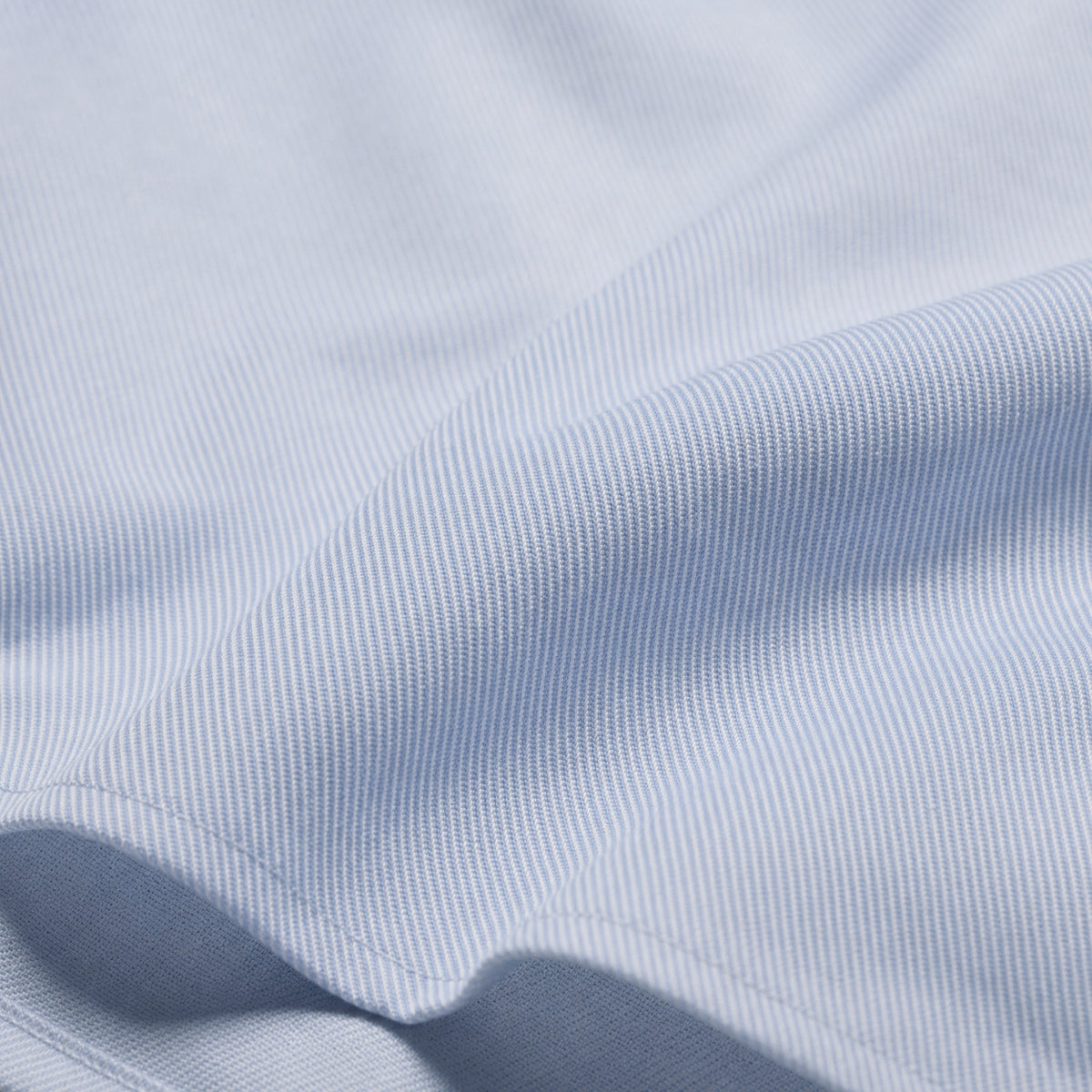Light blue dress shirt fabric close-up with fine twill texture