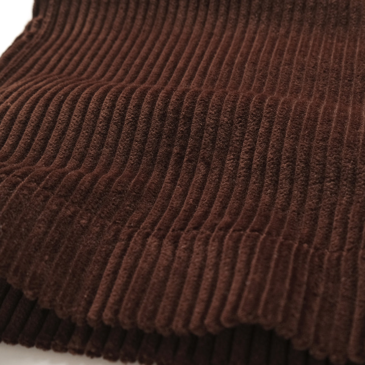 Dark brown wide-wale corduroy fabric with vertical ribbed texture.