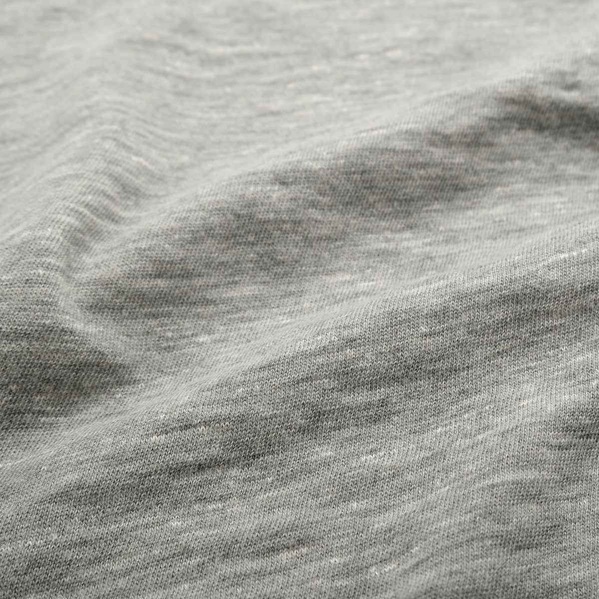 Heather gray slub knit fabric close-up, textured jersey surface