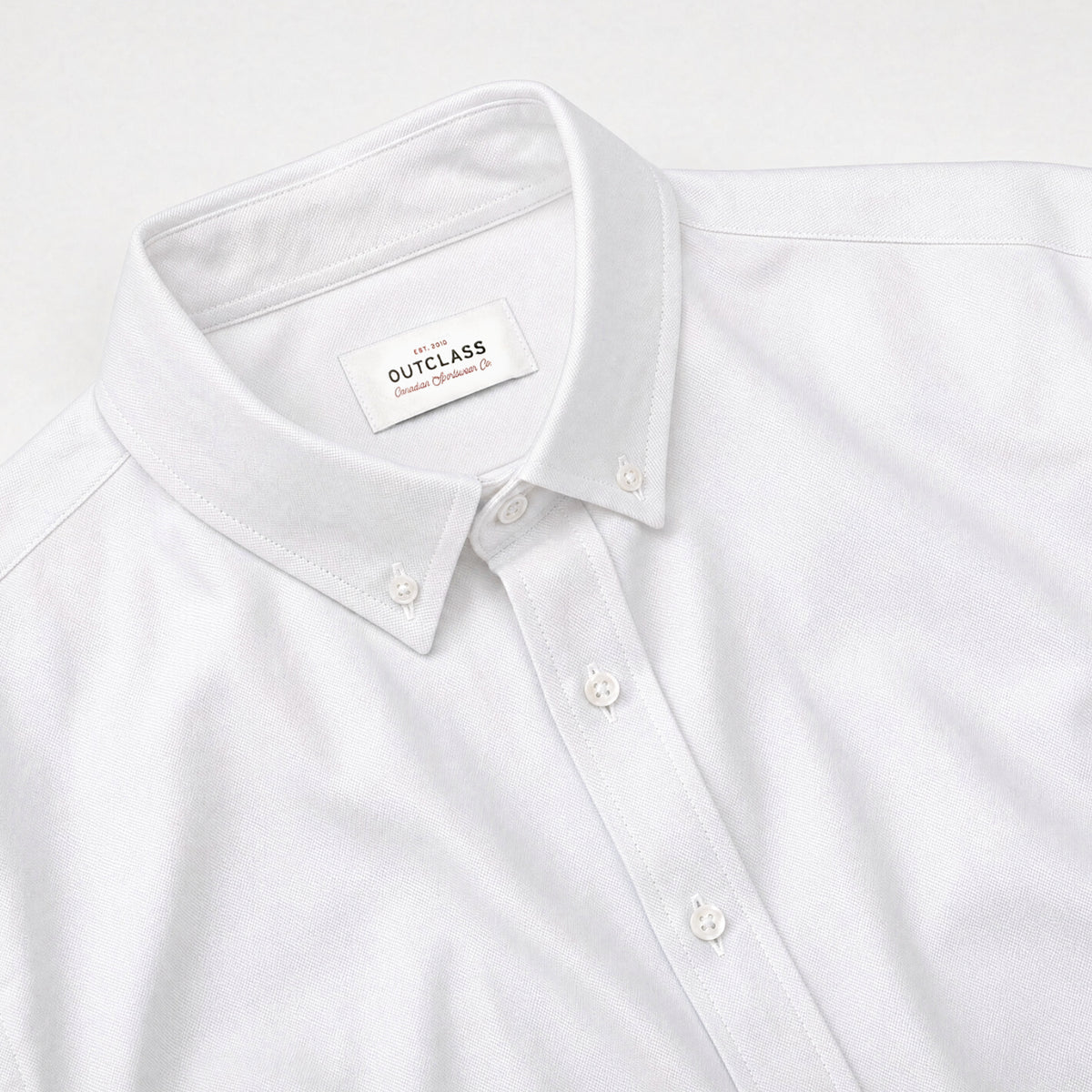 White Oxford shirt neckline with collar, front buttons, and label