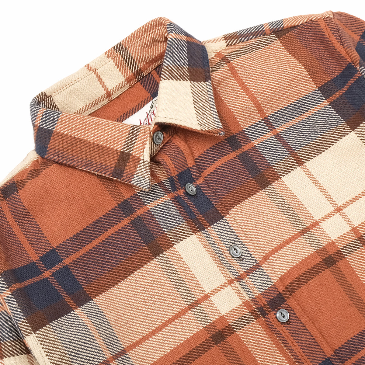 Plaid easy shirt close-up with spread collar and button placket, rust and navy