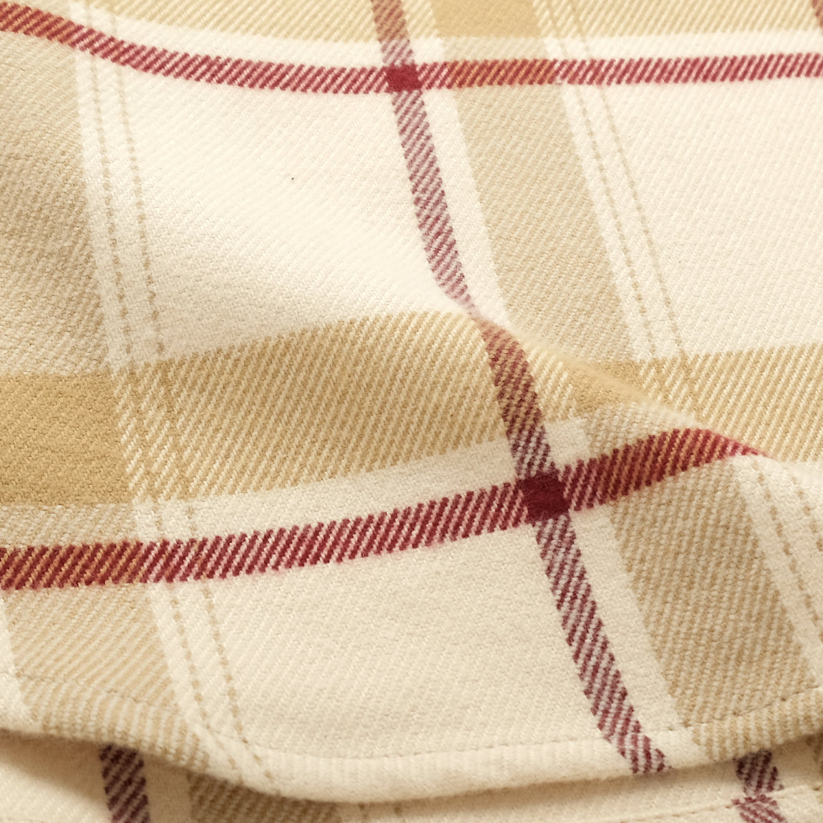Ecru plaid flannel fabric close-up with woven texture and red/brown checks