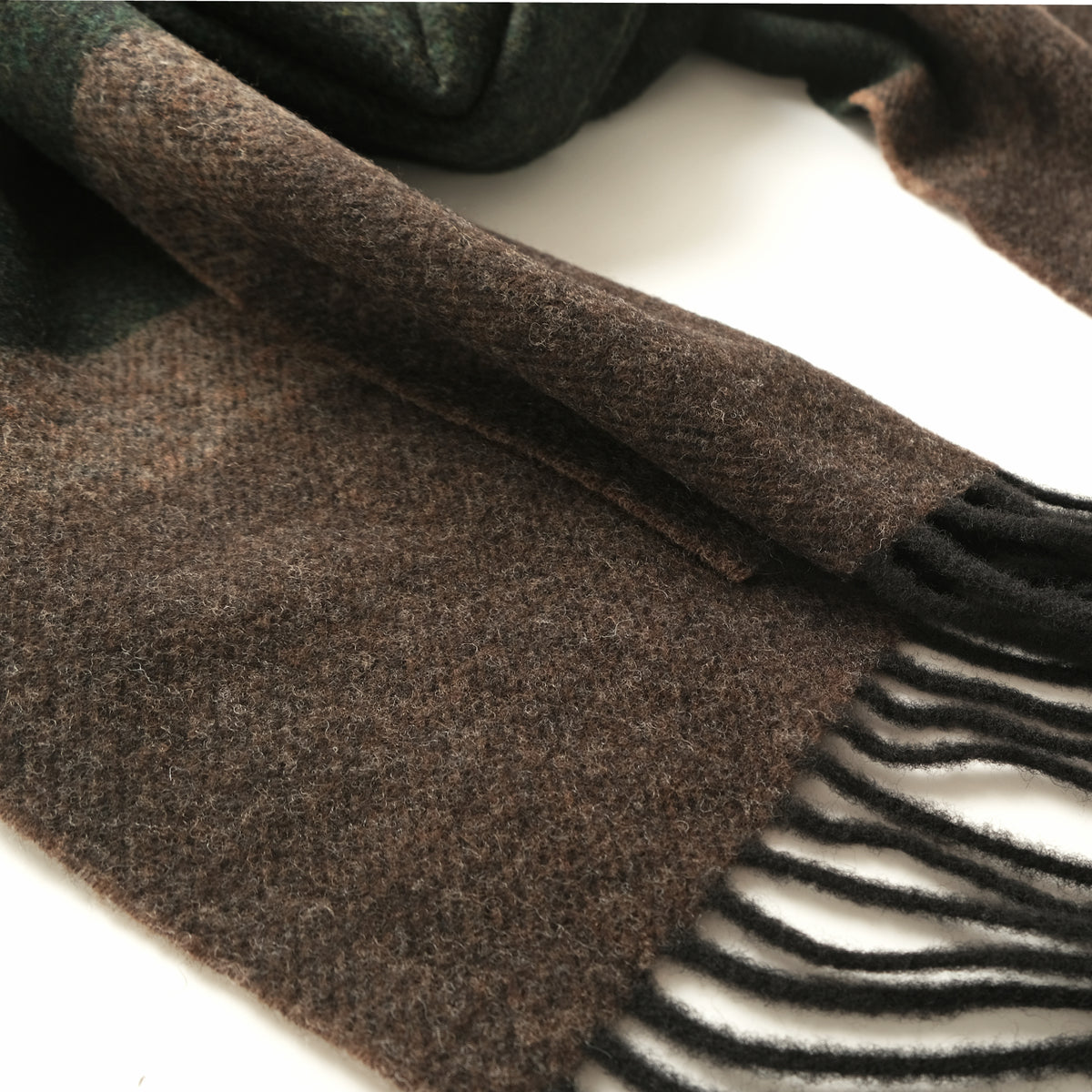 Close-up of dark green and brown striped scarf with textured weave and fringe
