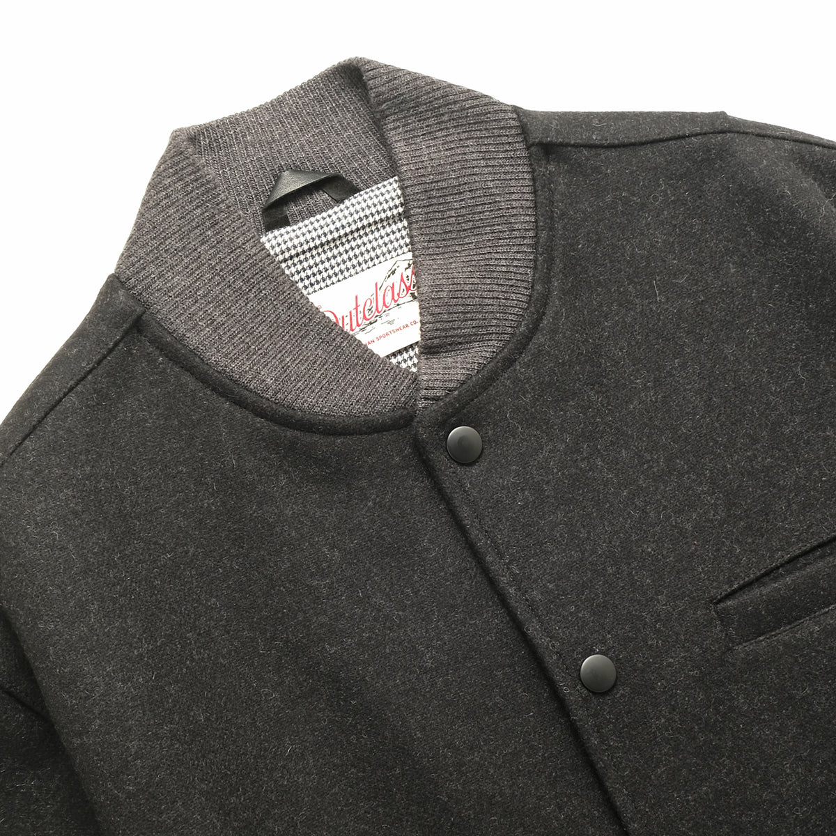 Charcoal stadium jacket close-up with ribbed stand collar and snap button placket