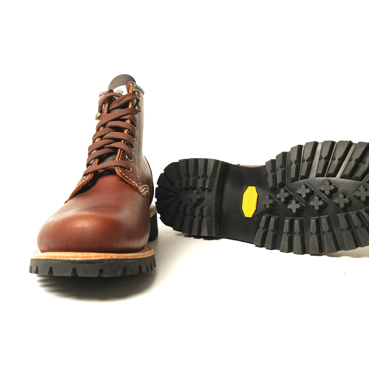 Brown hiking boot with rugged black tread sole and yellow brand patch detail.