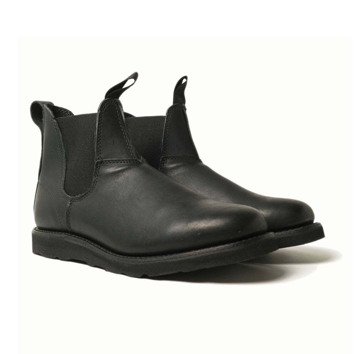 Black Chelsea boot angled view, elastic gore panels and side pull tabs, rubber sole