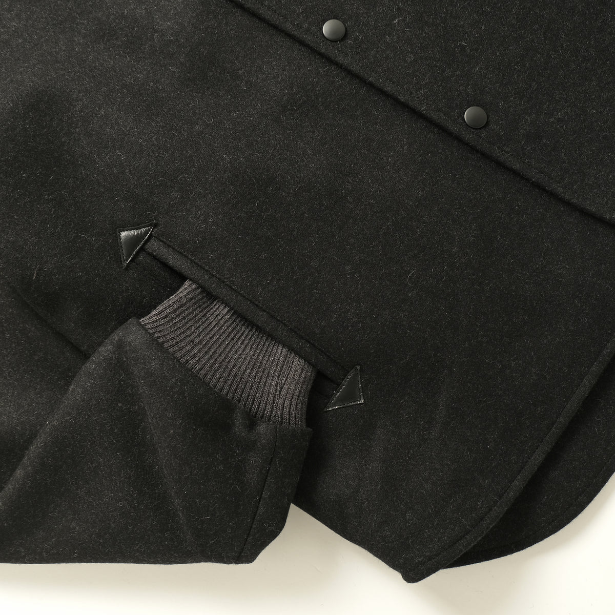 Charcoal stadium jacket side view with ribbed cuffs and snap buttons