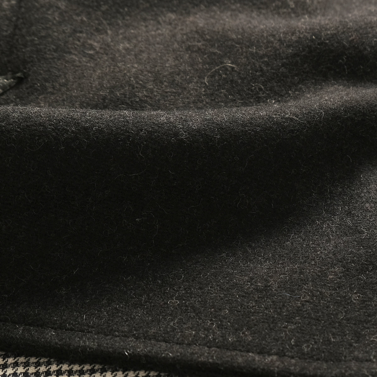 Charcoal jacket fabric close-up with dense heathered texture