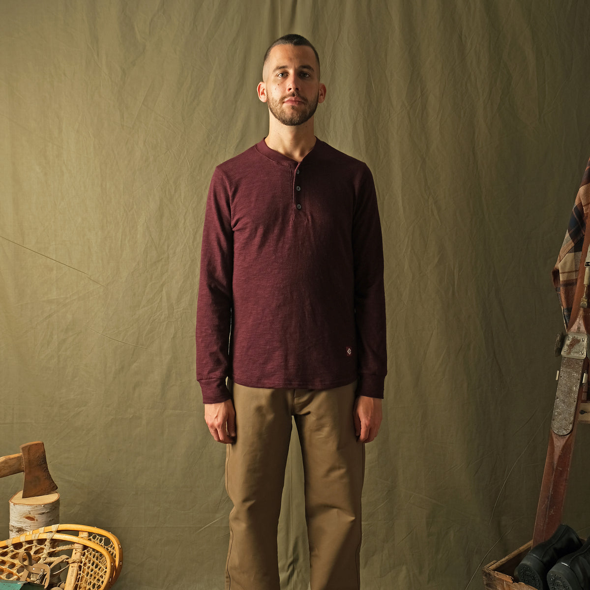 Maroon long-sleeve henley shirt on model, buttoned neckline