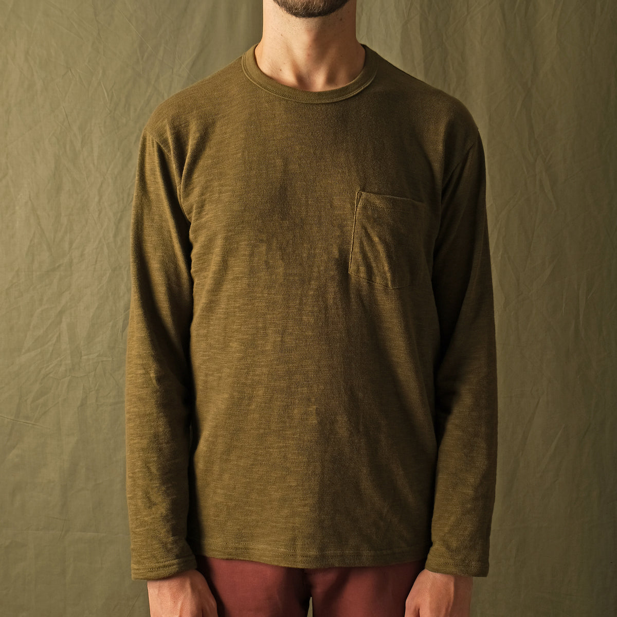 Olive long-sleeve pocket T-shirt on model, textured slub knit