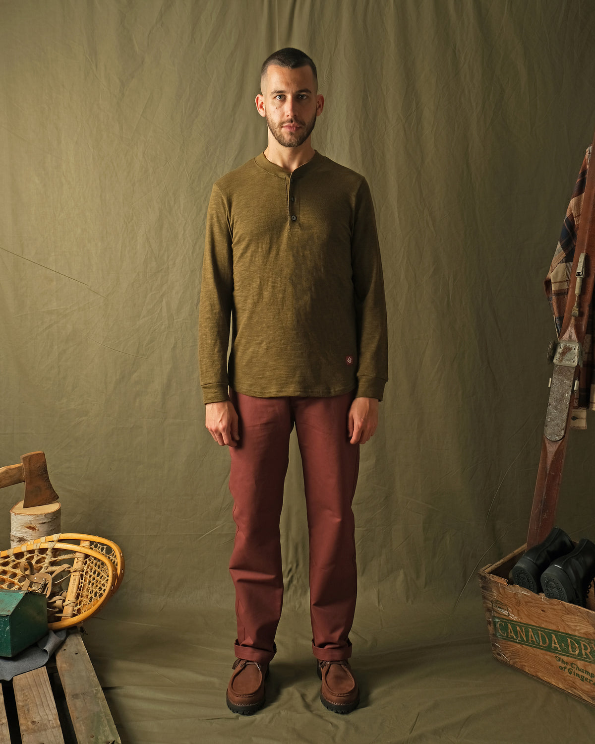 Olive long-sleeve henley shirt worn by model, 3-button placket and ribbed cuffs
