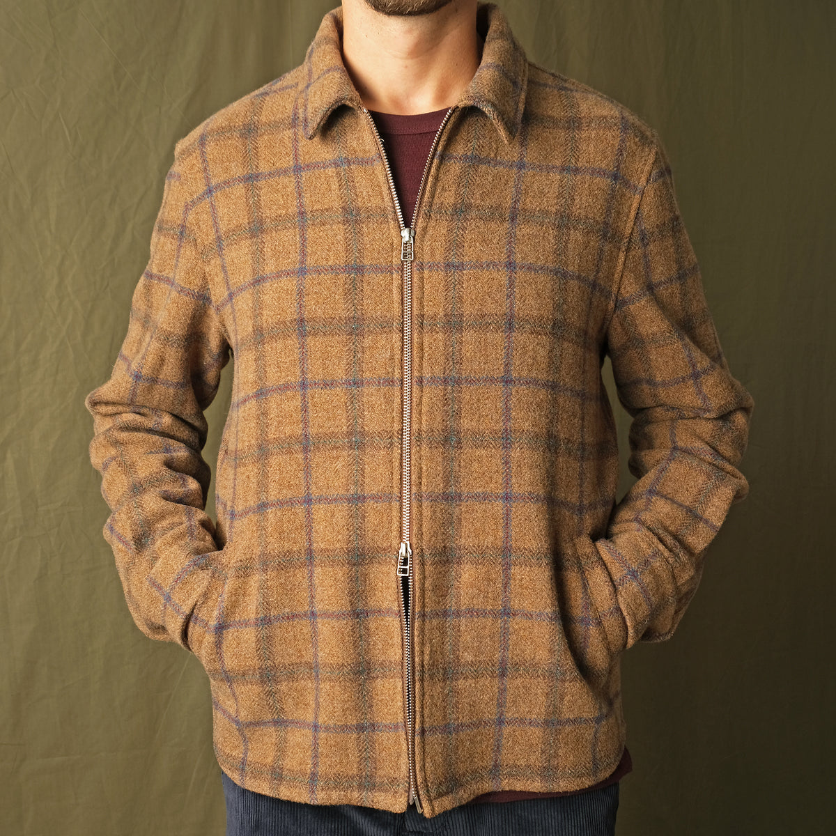 Wool plaid zip overshirt on model torso, stand collar, long sleeves, metal zipper