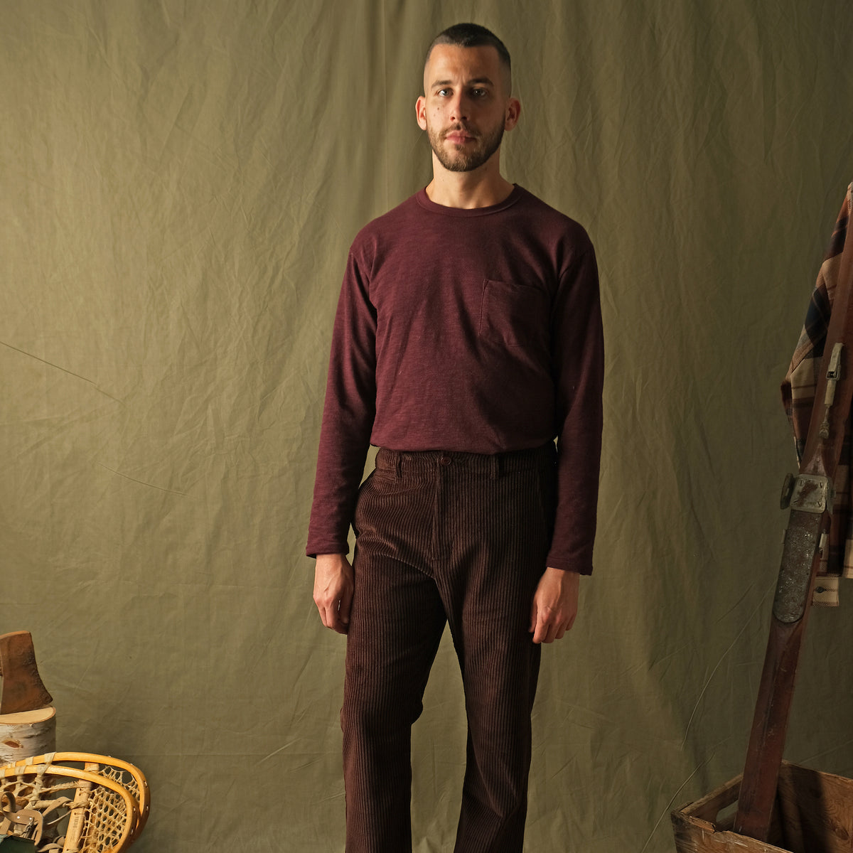 Dark brown corduroy camp pants on model, relaxed wide leg silhouette.