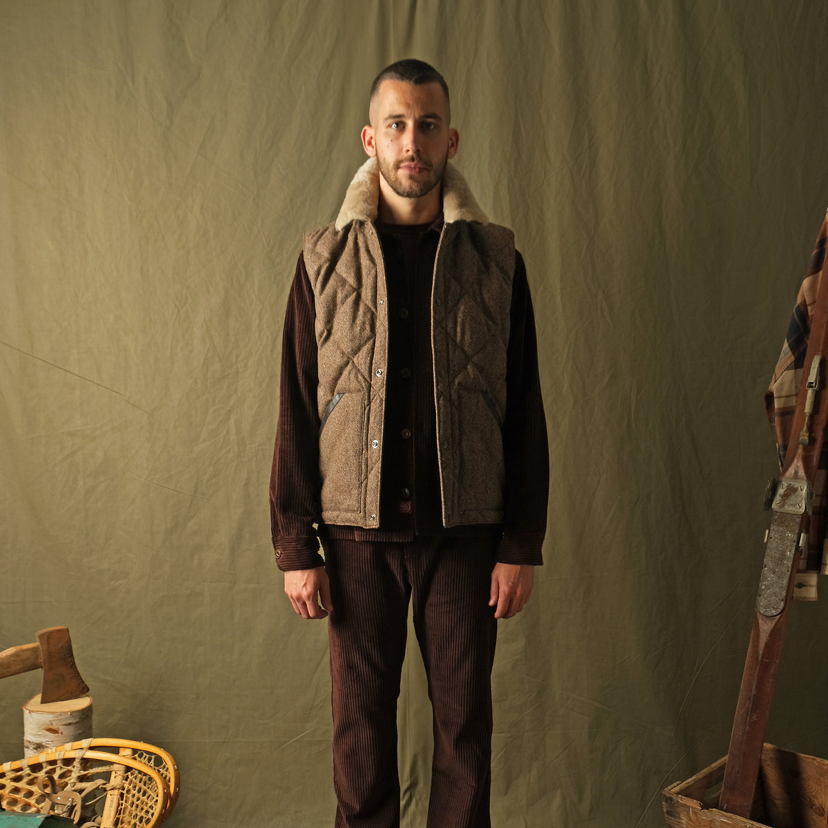 Brown diamond-quilted down vest with tan sherpa collar on model, front view