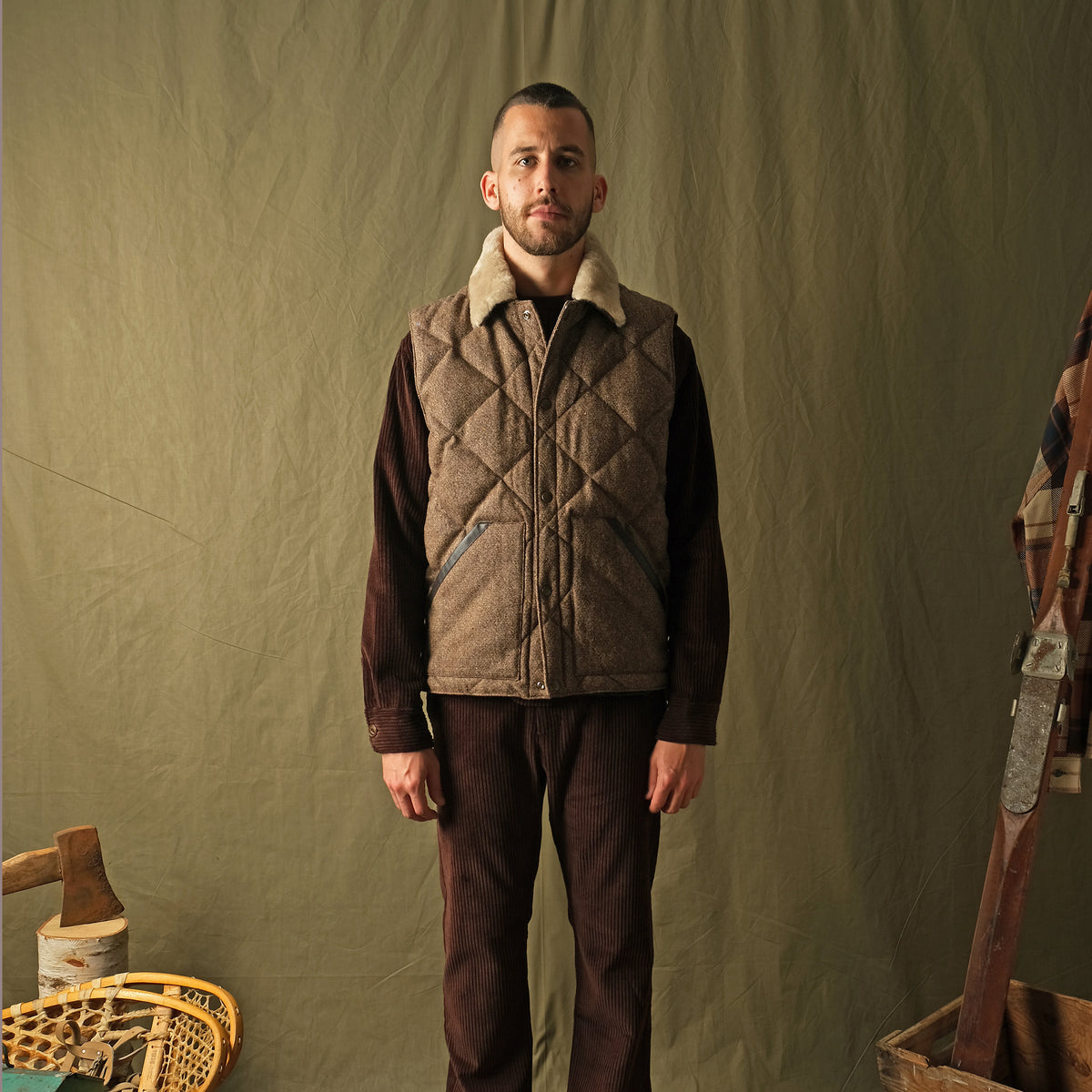 Brown diamond-quilted down vest with tan sherpa collar on model, full front