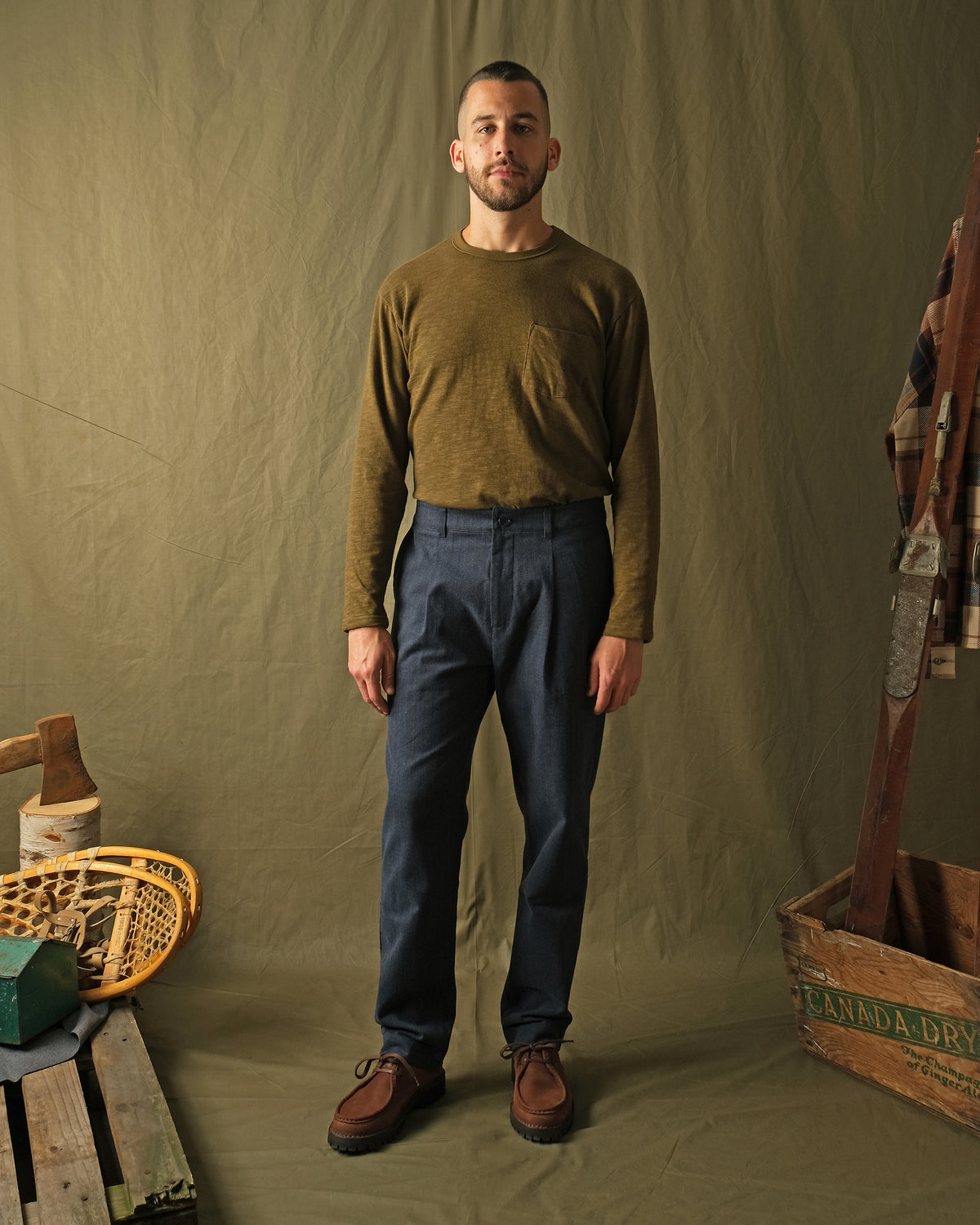 Navy herringbone pleated pants worn with casual top; straight leg fit