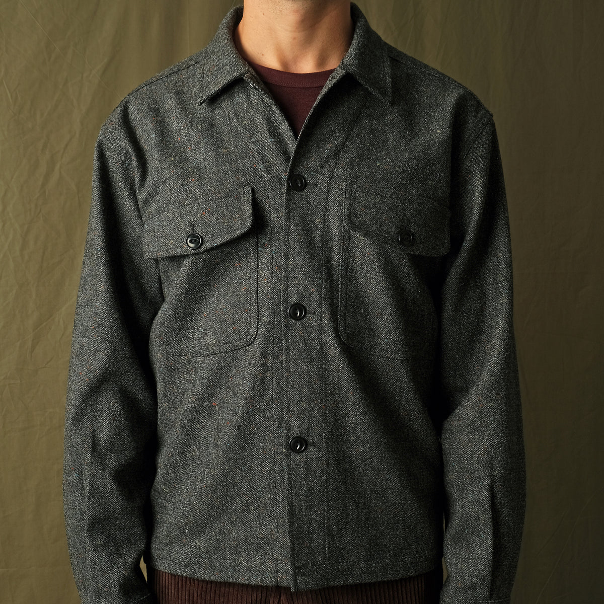 Charcoal fleck wool camp shirt with camp collar and flap chest pockets visible on model.