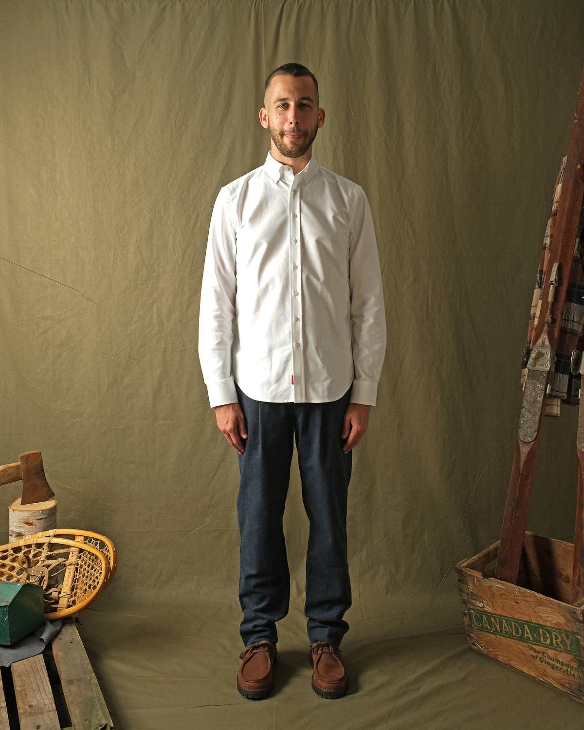 White Oxford button-up shirt on model with long sleeves and buttoned front