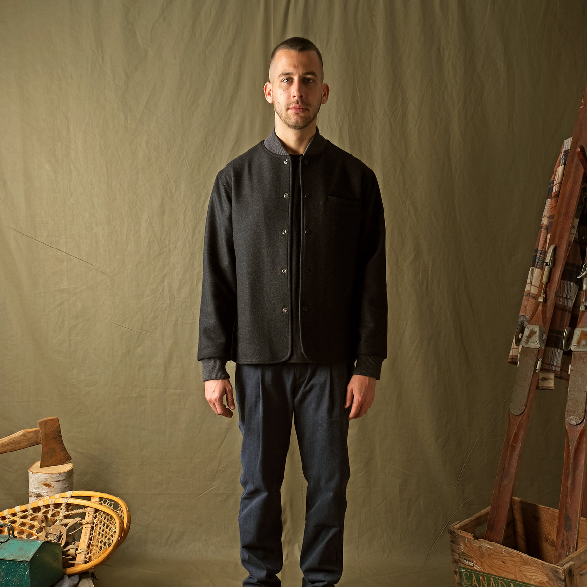 Charcoal stadium jacket worn by model, stand collar and front welt pockets