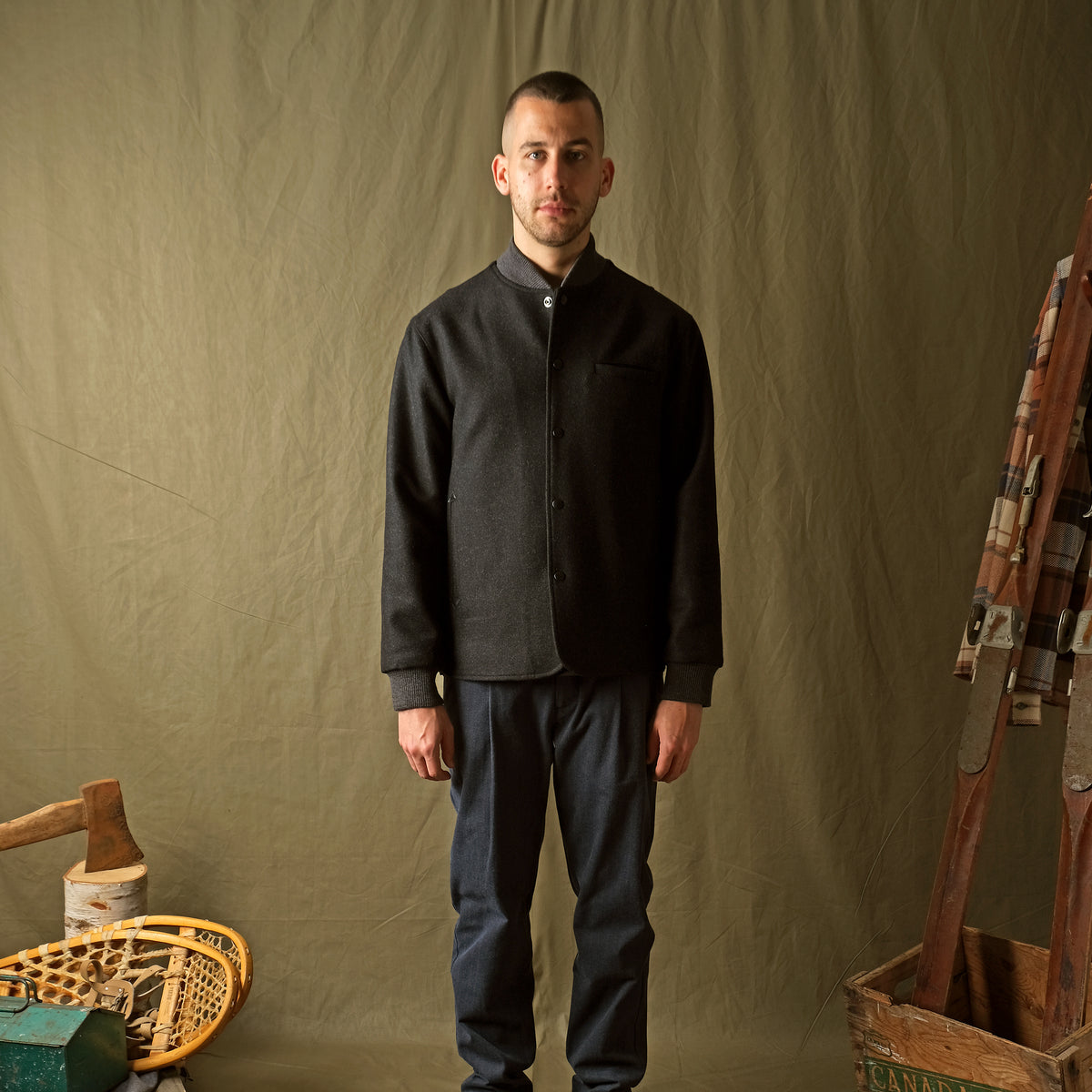 Charcoal stadium jacket worn by model, snap-up front with ribbed hem and cuffs