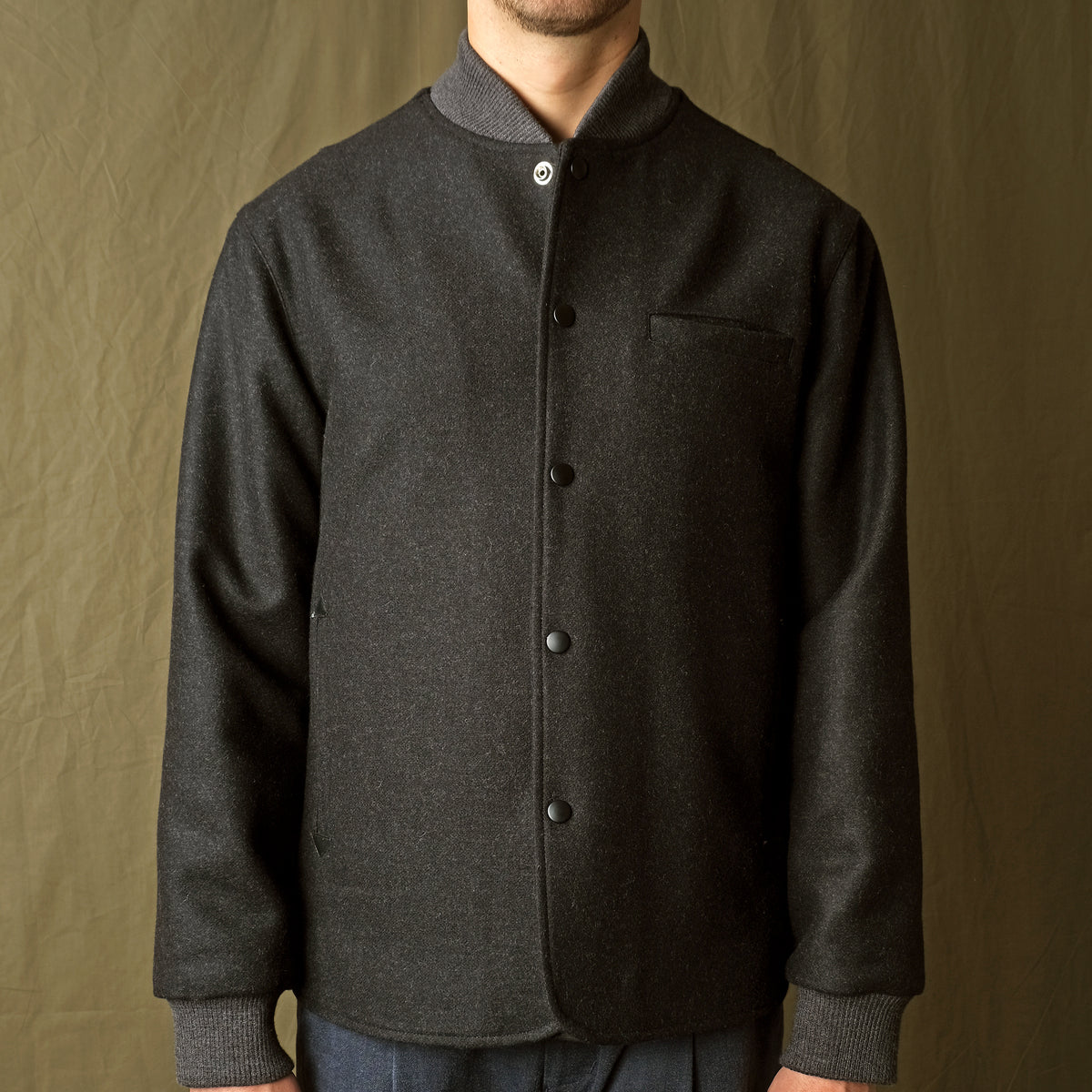 Charcoal stadium jacket close-up with stand collar and snap buttons