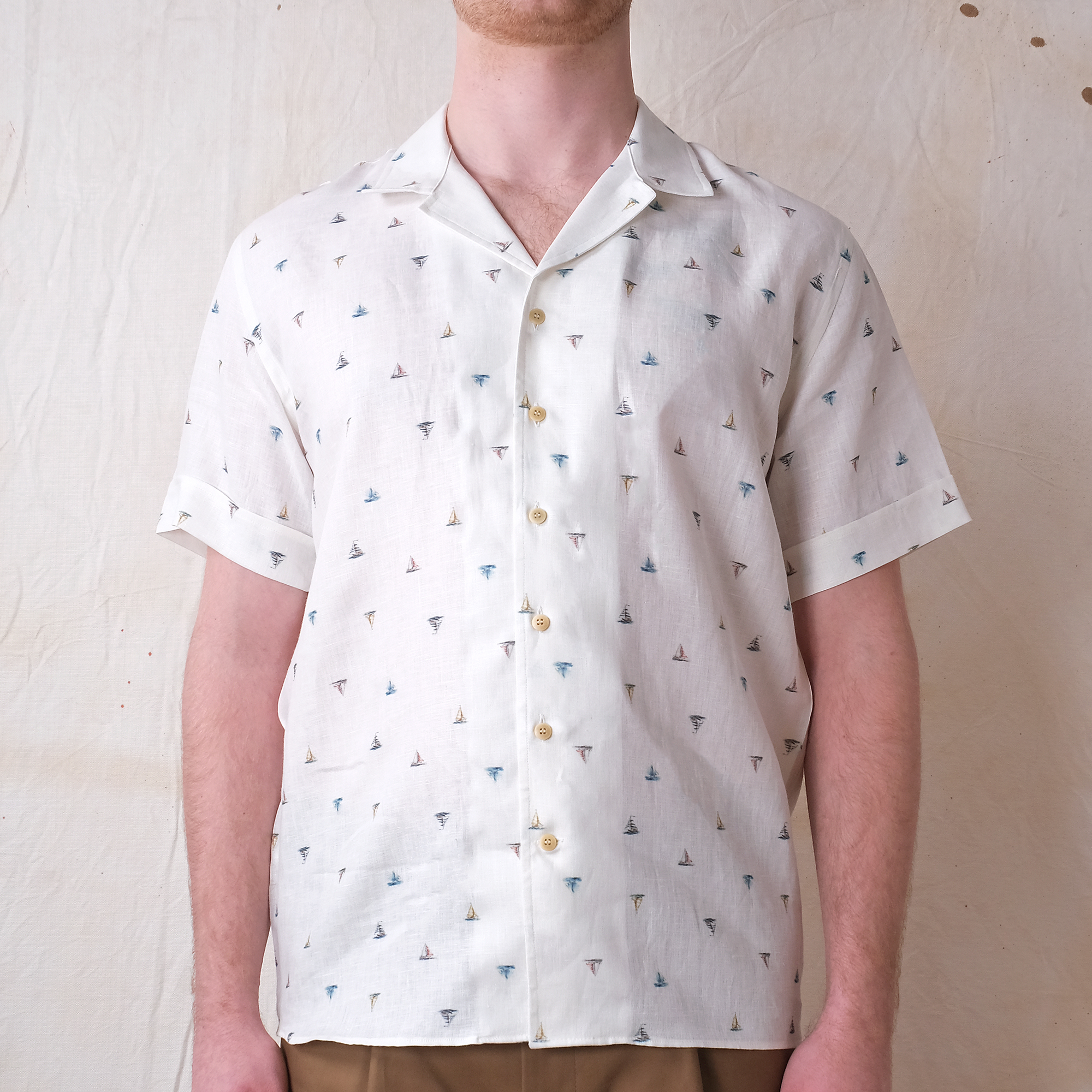 White short-sleeve button-up shirt with sailboat pattern and gold-tone buttons