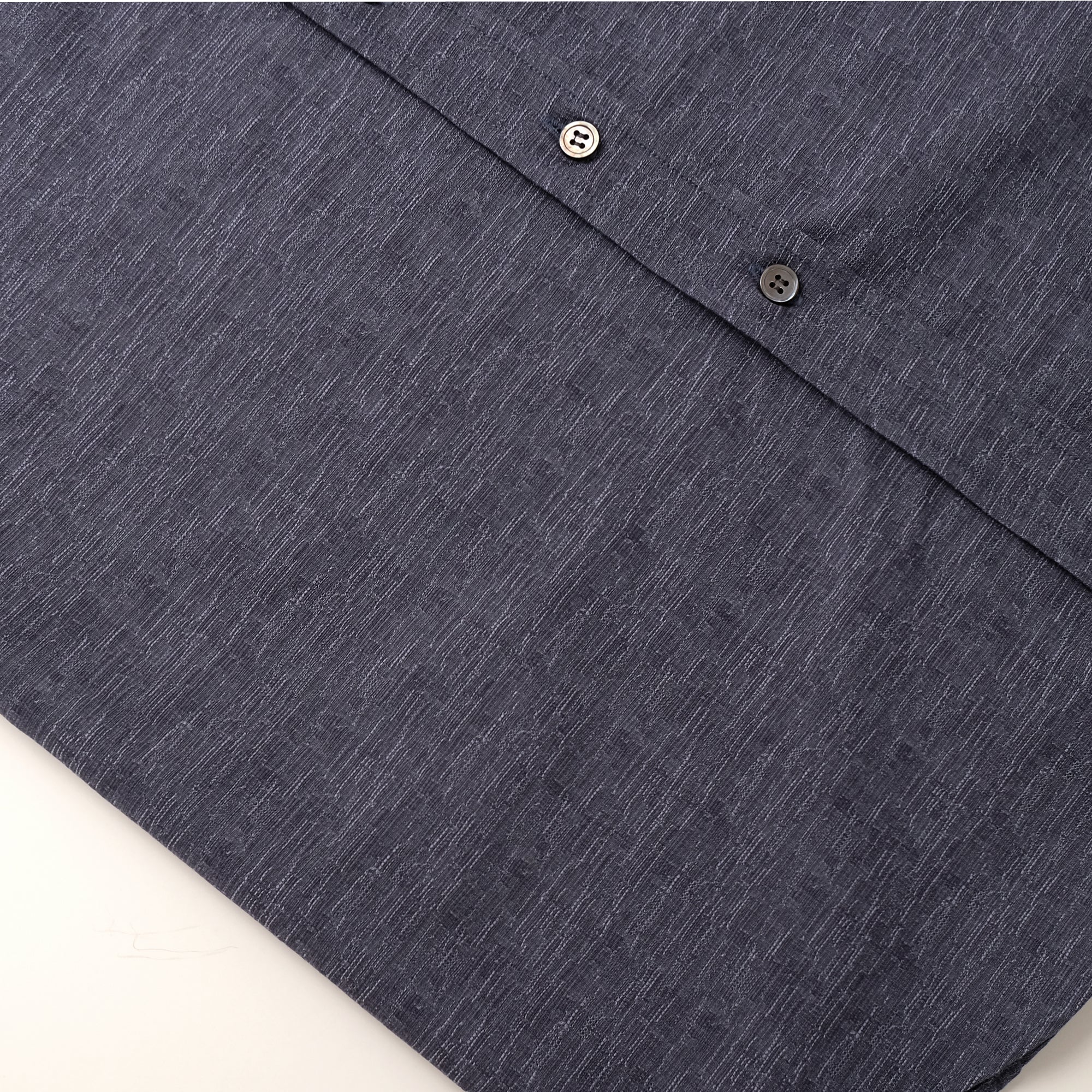 Slate blue shirt collar and button placket detail with dark buttons