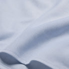 Light blue dress shirt fabric close-up with fine twill texture