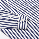 Navy-and-white striped dress shirt cuff and sleeve with white buttons