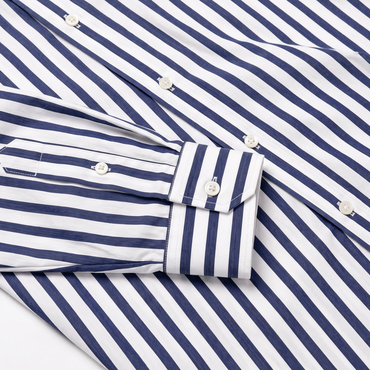 Navy-and-white striped dress shirt cuff and sleeve with white buttons