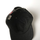 Dark wool field cap interior view with stitched panels and neck label