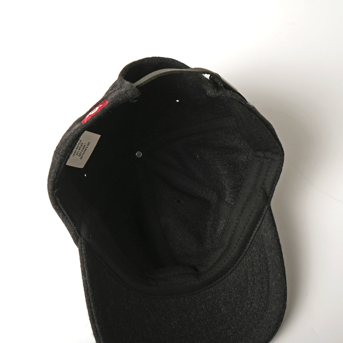 Dark wool field cap interior view with stitched panels and neck label