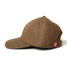 Brown wool field cap with curved brim and red side label