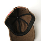 Brown wool field cap interior with black panels and top button