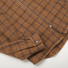 Wool plaid zip overshirt detail with metal zipper and chest pockets, folded front view