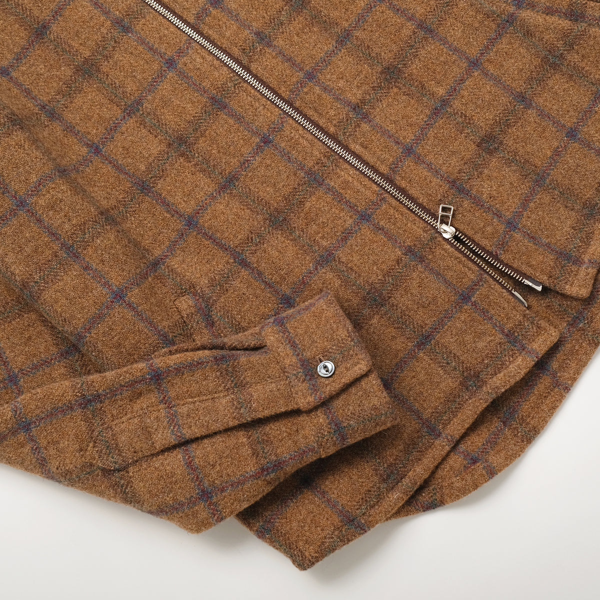 Wool plaid zip overshirt detail with metal zipper and chest pockets, folded front view