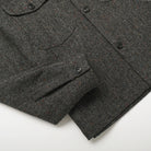 Charcoal fleck wool camp shirt, angled view showing button placket and patch pockets.