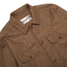 Brown wool camp shirt close-up: hazel-fleck texture, button front, pointed collar