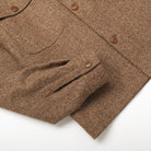 Brown wool camp shirt detail: flap chest pocket and buttoned placket
