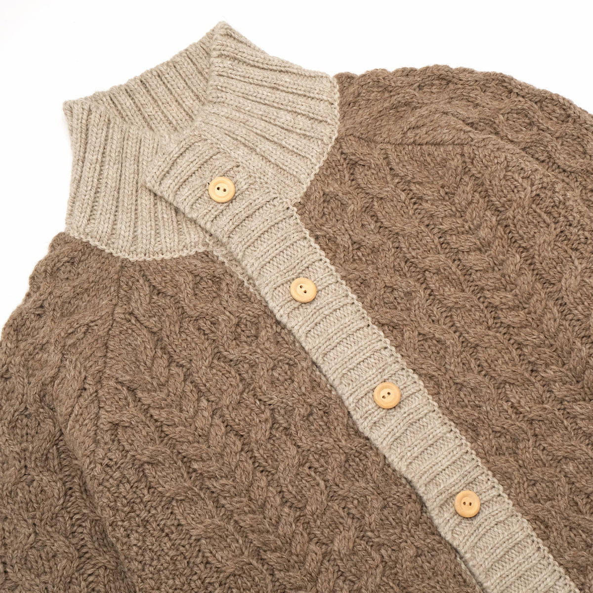 Cable knit cardigan with cream mock neck band and wood-look button placket