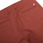 Brick red engineer pants with front slant pockets and back waist tab; logo label