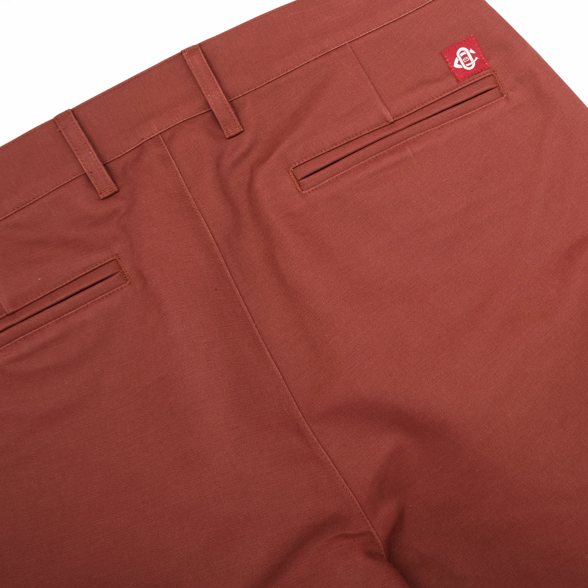 Brick red engineer pants with front slant pockets and back waist tab; logo label