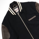 Navy bomber jacket with striped ribbed collar, metal zipper, and chest pocket