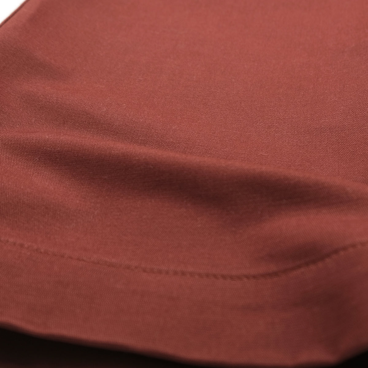 Brick red moleskin fabric hem with stitched seam and cuff