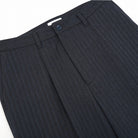 Navy herringbone pleated pants close-up of waistband and front pleats