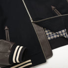 Navy bomber jacket with zipper front, side pockets, and striped ribbed sleeve cuff