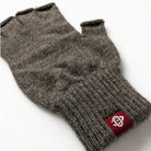 Dark gray wool fingerless glove closeup with knit texture and red logo patch