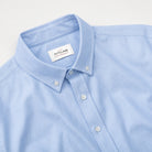 Light blue button-up shirt collar with buttons and neck label