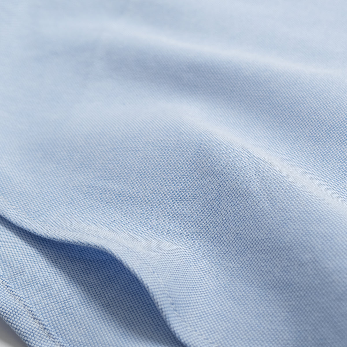 Light blue oxford shirt fabric close-up with fine woven texture